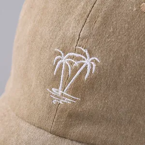 Macro detail of white palm tree embroidery on khaki corduroy baseball cap fabric