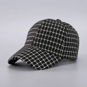 Detailed close-up of houndstooth tweed baseball cap showing woven texture and frayed brim