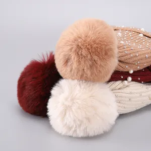 Detail der Winterstrickmütze mit Perlen, Strasssteinen und flauschigem Bommel