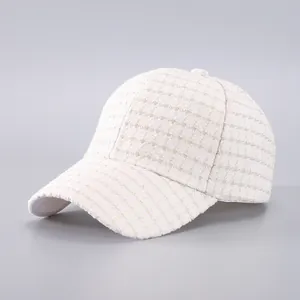 Close-up of cream baseball cap featuring fine checkered tweed fabric and premium texture