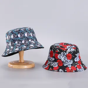 Detalle de sombreros de pescador reversibles con estampados de calaveras y flores en lona