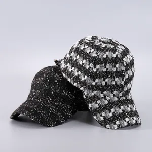 Detail shot of tweed baseball caps showing black and checkered woven textures
