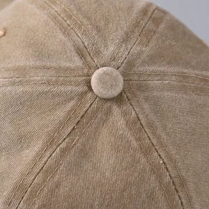 Macro shot of embroidered baseball cap top with washed cotton texture and stitching