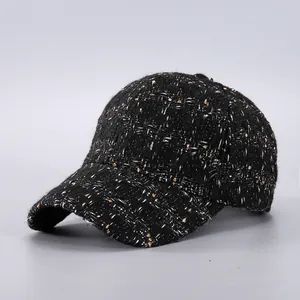 Close-up of black tweed baseball cap with white and gold metallic fiber textures