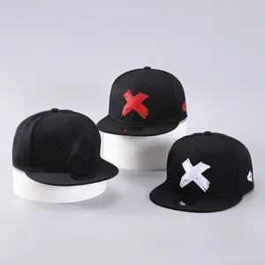 Detailed embroidery on three black snapback caps displayed on white circular stands
