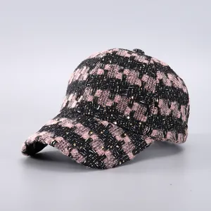 Detail of tweed baseball cap featuring pink and black weave with golden sequins