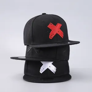 Vertical stack of three black snapback hats with red, white, and black embroidered X logos