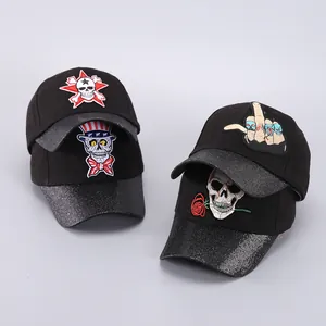 Detalle de gorras de béisbol de Halloween con visera de lentejuelas y bordado de calavera