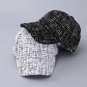 Close-up of black and white houndstooth tweed texture on stylish baseball caps