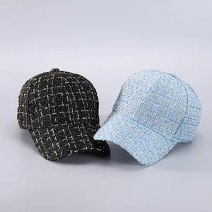 Detail of tweed baseball caps with houndstooth texture in black and light blue gold weaves