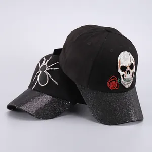 Detalle de gorra de béisbol negra con visera de lentejuelas y bordados de calavera y araña