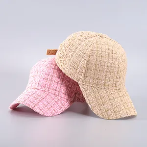 Detail of pink and beige tweed baseball caps featuring metallic gold thread texture