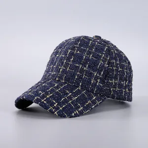Detail of navy tweed baseball cap with gold metallic threads and textured weave pattern