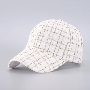 Macro shot of the white tweed texture with sparkling gold threads on the baseball cap