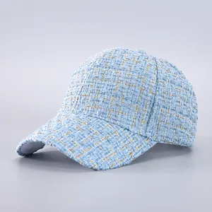Detailed view of light blue tweed baseball cap with metallic gold thread texture