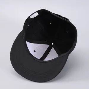 Detail view of 6-panel stitching and inner lining of a black flat brim hip hop cap