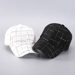 Detailed close-up of black and white houndstooth tweed baseball caps with gold silk threads