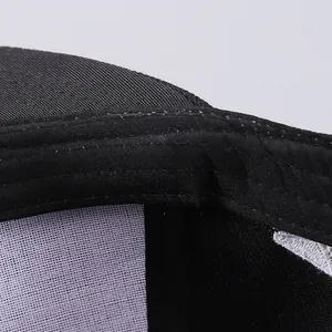 Macro view of black twill baseball cap interior with mesh lining and neat stitching details