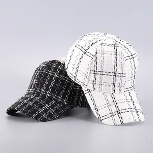 Close-up detail of the textured houndstooth weave on black and white tweed baseball caps