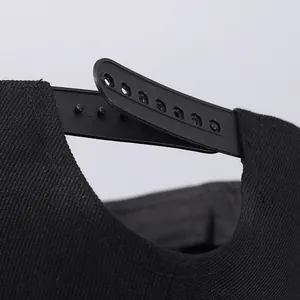 Rear view of black cotton snapback hat with adjustable 7-hole plastic closure strap