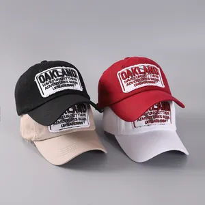 Nahaufnahme von vier Retro-Baseballkappen in Schwarz, Khaki, Rot und Weiß mit Oakland-Stickerei