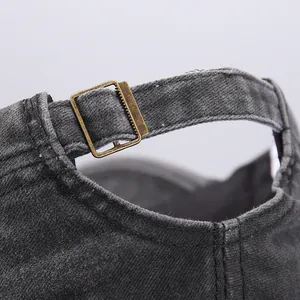 Detailed macro of the antique brass metal buckle and washed denim strap on military cap