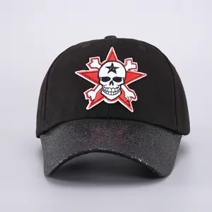 Detalle del bordado de calavera en gorra negra con visera de lentejuelas