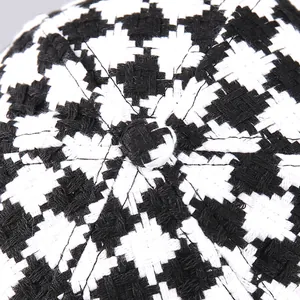 Macro detail of houndstooth woven fabric and central top button on a baseball cap