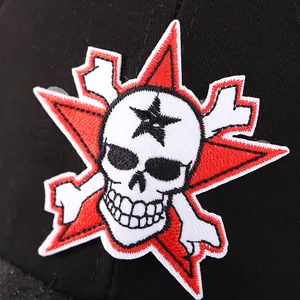 Detalle de bordado 3D de calavera con estrella roja sobre gorra de béisbol de algodón negro