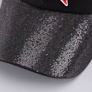 Primer plano de la visera de lentejuelas negras de la gorra con detalles bordados