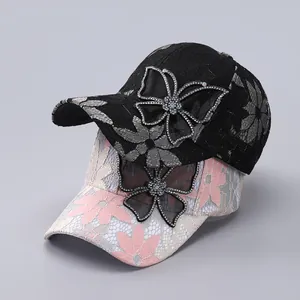 Close-up of lace baseball cap with floral pattern and rhinestone butterfly detail
