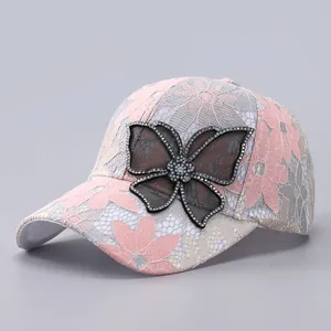 Close-up of pink lace baseball cap with sparkling rhinestone butterfly and mesh detail