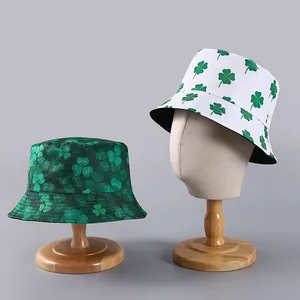Detail view of St. Patrick's Day bucket hats with green clover prints on wooden stands