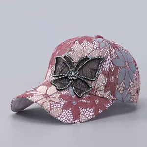 Detailed view of lace floral embroidery and sparkling rhinestone butterfly on baseball cap