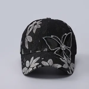Detail of black lace baseball cap with sparkling butterfly rhinestone and floral mesh
