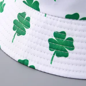 Detailed close-up of white bucket hat featuring green clover prints and precision stitching