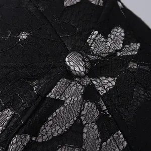 Close-up of black mesh baseball cap showing silver grey floral lace and stitching details