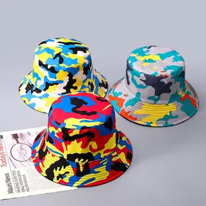 Vue détaillée de trois bobs camouflage colorés sur un fond de journal de mode élégant