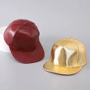 Detail of burgundy and metallic gold PU leather snapbacks with faux snakeskin texture