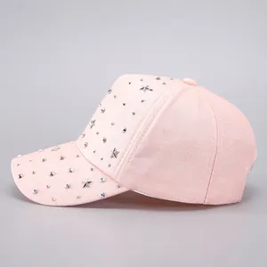 Close-up of light pink baseball cap with silver star rivets and sparkling rhinestones