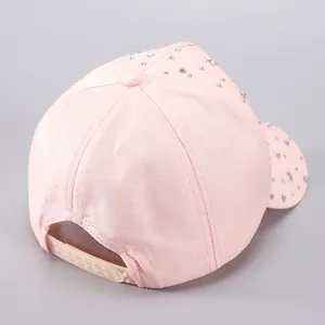 Detailed back view of pink baseball cap with heart and star rivets and adjustable snapback