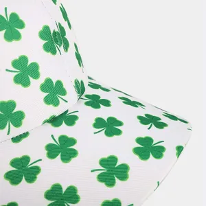 Detail of green shamrock pattern and stitching on a white canvas baseball cap