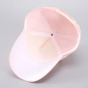 Detail of light pink baseball cap showing inner six-panel structure and breathable mesh fabric