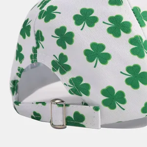 Detail of the white baseball cap showing the adjustable metal buckle and green clover print