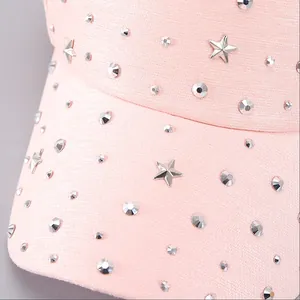Pink baseball cap featuring starry studs and metallic rivets on textured fabric