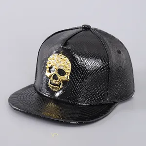 Detailed view of the gold skull emblem on black snakeskin texture snapback cap