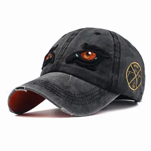 Detailed embroidery of eyes on distressed grey cotton baseball cap with orange brim underside
