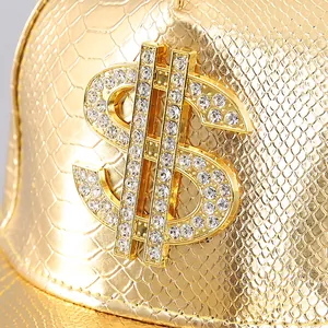 Detailed close-up of golden faux-leather cap featuring a crystal-studded dollar sign