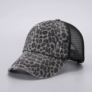 Detail showing leopard print baseball cap with distressed brim and breathable black mesh back