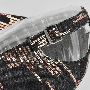 Close-up of adjustable strap on black denim baseball cap with rose gold sequins